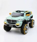 Un jeune garçon souriant au volant de son nouveau 4x4 électrique enfant style BMW vert avec des jantes jaunes.