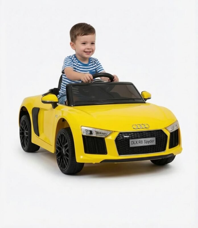 Enfant portant un casque et des lunettes de soleil assis au volant d'une voiture électrique enfant Audi R8 Spyder 12V jaune avec logo quatre anneaux et plaque DLX R8 Spyder
